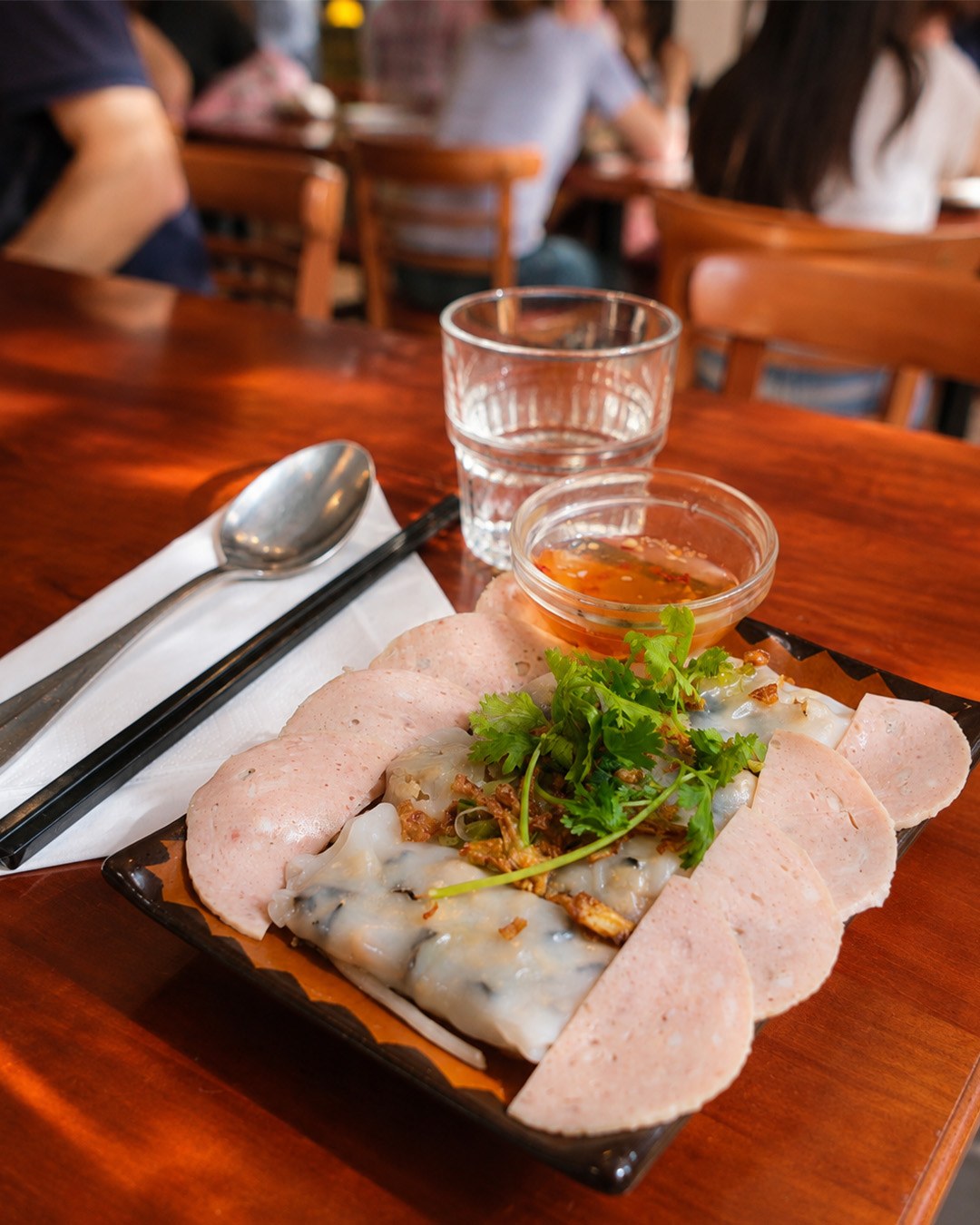 Assiette de rouleaux de riz garnis entourés de tranches de charcuterie vietnamienne